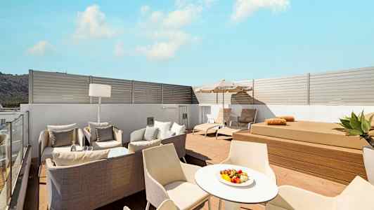 Moderni kattoterassi, jossa aurinkotuoleja, istuinryhmä ja pöytä. (Tekoälyn luoma teksti)