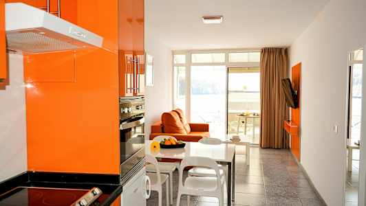 Moderni keittiö ja olohuone oranssilla sisustuksella ja näkymä merelle. (Tekoälyn luoma teksti)