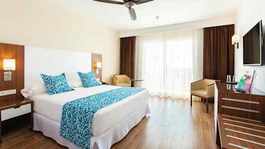 Hotellihuone, jossa on parivuode, siniset tekstiilit ja moderni sisustus. (Tekoälyn luoma teksti)