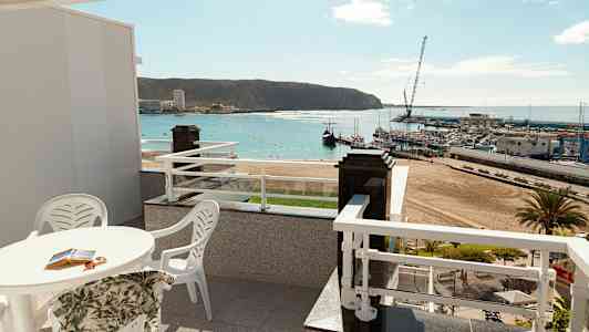 Terassi, jolta on näkymä rannalle ja satamaan. (Tekoälyn luoma teksti)