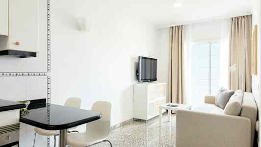 Valoisa olohuone, jossa sohva, pöytä, televisio ja ruokailutila. (Tekoälyn luoma teksti)