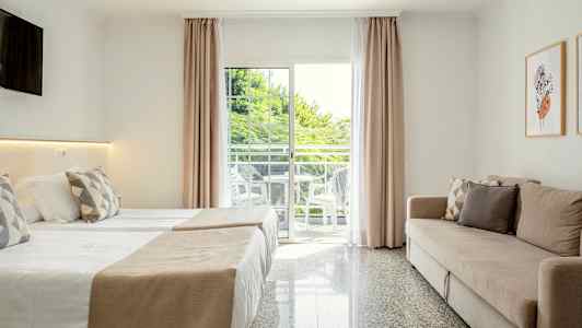 Moderni hotellihuoneen sisustus, jossa on vuodesohva, kaksi sänkyä ja parveke näkymällä. (Tekoälyn luoma teksti)