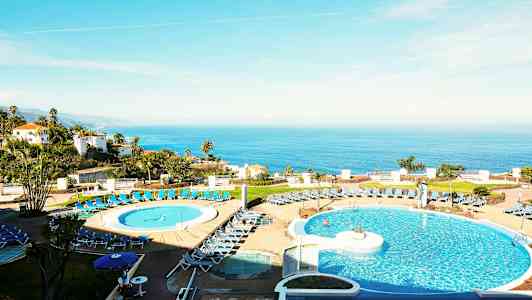 Kuva hotellista, jossa etualalla on uima-allasalue ja taustalla merinäkymä. (Tekoälyn luoma teksti)