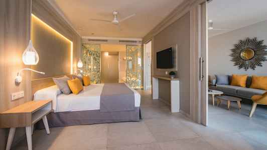 Hotellihuone, jossa sänky, istuinalue ja TV. (Tekoälyn luoma teksti)