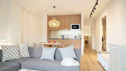 Nykyaikaisesti sisustettu olohuone keittiöosalla ja ruokapöydällä. (Tekoälyn luoma teksti)