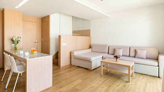 Moderni olohuone, jossa on puuelementtejä, sohva, sohvapöytä ja ruokailutila tuoleineen. (Tekoälyn luoma teksti)