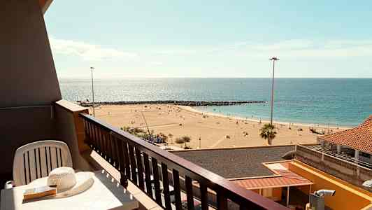 Parveke, jolta näköala hiekkarannalle ja merelle. (Tekoälyn luoma teksti)