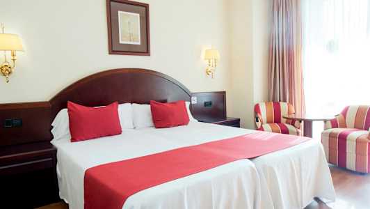 Parihuone punaisella sisustuksella ja kaksi nojatuolia. (Tekoälyn luoma teksti)