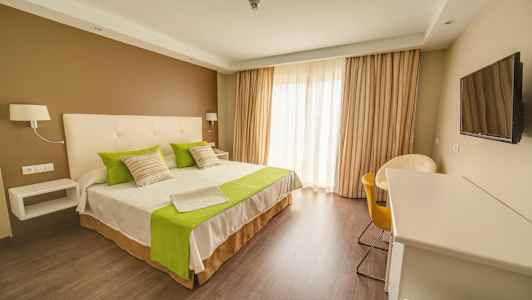 Hotellihuone, jossa on parivuode, vihreät yksityiskohdat ja nykyaikainen sisustus. (Tekoälyn luoma teksti)