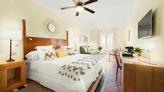 Valoisa hotellihuone, jossa on parivuode, puiset yksityiskohdat ja moderni sisustus. (Tekoälyn luoma teksti)