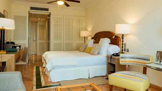 Hotellihuone, jossa on parivuode, kirjoituspöytä ja tuoli. (Tekoälyn luoma teksti)