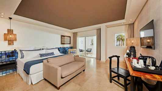 Hotellihuone, jossa parivuode, sohva, työpöytä, televisio ja parveke. (Tekoälyn luoma teksti)