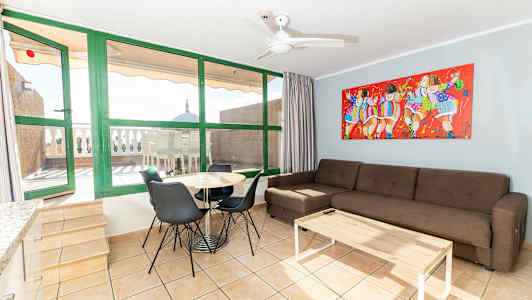 Olohuone, jossa sohva, ruokapöytä ja tuolit. Taustalla näkyy terassi, jossa pöytä ja tuolit. (Tekoälyn luoma teksti)