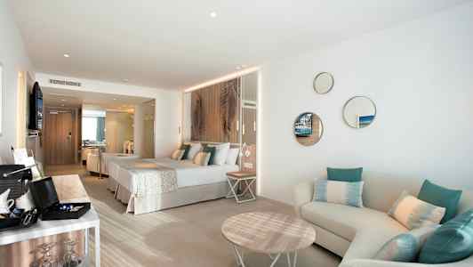 Moderni hotellihuone, jossa on parivuode, istuma-alue ja sisustuselementtejä. (Tekoälyn luoma teksti)