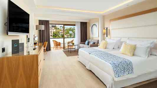 Hotellihuone, jossa kaksi sänkyä, istuinryhmä ja parveke. (Tekoälyn luoma teksti)