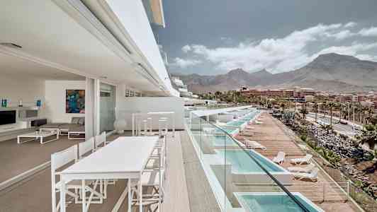 Terassi, jolta on näkymät altaisiin ja vuorille taustalla. (Tekoälyn luoma teksti)