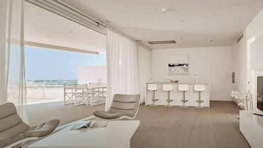 Kuva modernista olohuoneesta, jossa avoin pohjaratkaisu, vaaleat huonekalut ja näkymä terassille. (Tekoälyn luoma teksti)