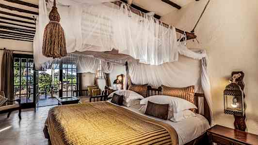 Makuuhuone, jossa on harkittu sisustus, parivuode katossängyllä ja pääsy terassille. (Tekoälyn luoma teksti)