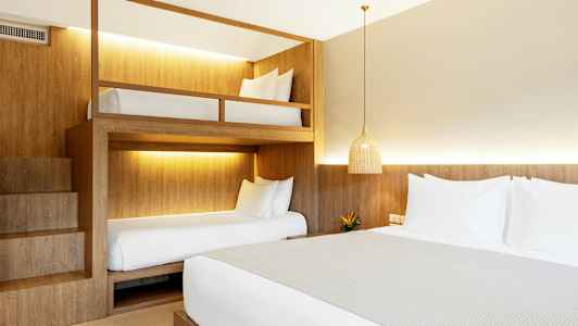 Hotellihuone, jossa on parisänky ja kerrossängyt. (Tekoälyn luoma teksti)