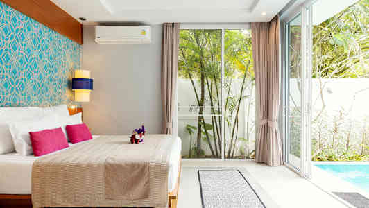 Makuuhuone, jossa parivuode, värikkäitä tyynyjä, tyylikäs sisustus ja näkymä altaalle ja puutarhaan. (Tekoälyn luoma teksti)