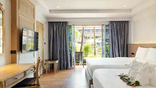 Hotellihuone, jossa kaksi sänkyä, kirjoituspöytä ja suuri ikkuna näkymällä uima-altaalle ja puutarhaan. (Tekoälyn luoma teksti)