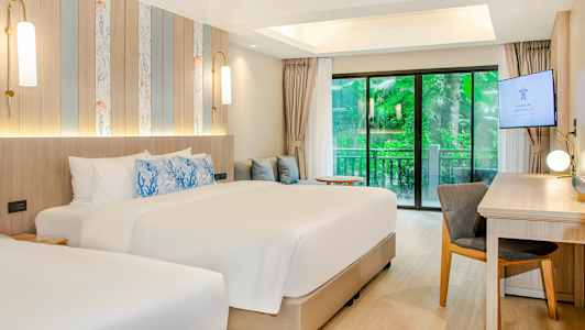 Moderni hotellihuone, jossa on kaksi sänkyä, kirjoituspöytä ja liukuovet vehreään näkymään. (Tekoälyn luoma teksti)