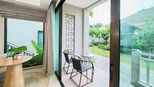 Näkymä huoneesta lasiovien kautta terassille, jossa on kaksi tuolia ja pöytä. (Tekoälyn luoma teksti)