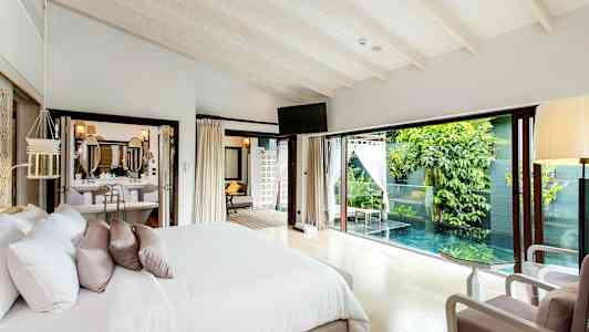 Makuuhuone, jossa on parivuode ja ikkuna yksityiseen altaaseen ja vehreyteen. (Tekoälyn luoma teksti)