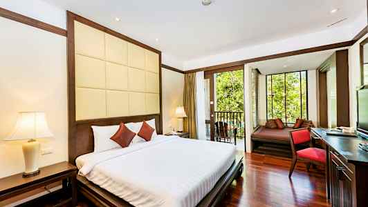 Hotellihuone, jossa parivuode, yöpöytä ja parveke, josta näkymä vehreään ympäristöön. (Tekoälyn luoma teksti)