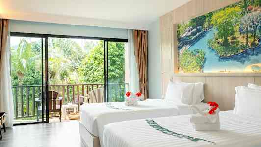 Valoisa hotellihuone, jossa on kaksi yhden hengen sänkyä ja näköala vehreään puutarhaan. (Tekoälyn luoma teksti)