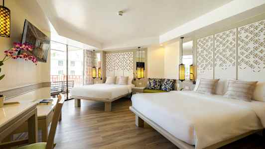 Hotellihuone, jossa kaksi suurta sänkyä, koristeellisia valaisimia ja pöytä kukalla. (Tekoälyn luoma teksti)