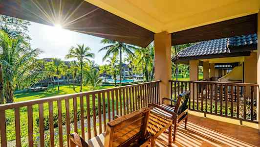 Näkymä parvekkeelta istuinpaikoilla kohti puutarhaa, jossa on palmuja. (Tekoälyn luoma teksti)