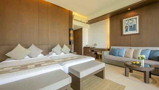 Hotellihuone, jossa kaksi sänkyä, sohva ja pöytä. (Tekoälyn luoma teksti)