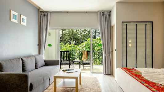 Modernisti sisustettu hotellihuone parvekkeella ja vihreä näkymä. (Tekoälyn luoma teksti)