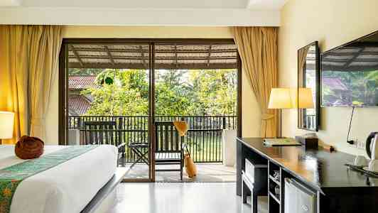 Hotellihuone, jossa on sänky, kirjoituspöytä ja parveke puutarhanäkymällä. (Tekoälyn luoma teksti)