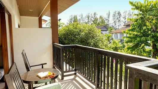 Näköala parvekkeelta, jossa pöytä, tuoleja ja puita ympärillä. (Tekoälyn luoma teksti)