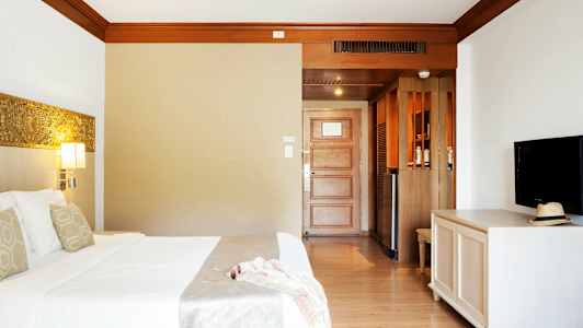 Hotellihuone, jossa sänky, televisio ja ovi. (Tekoälyn luoma teksti)