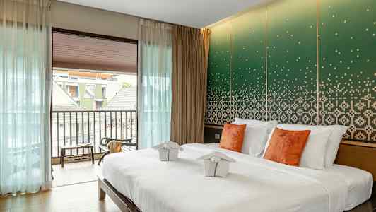 Moderni hotellihuone, jossa on parivuode ja koristeellinen seinä. (Tekoälyn luoma teksti)