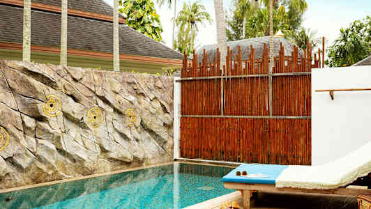 Yksityinen uima-allas, vieressä aurinkotuoli ja seinää koristavat kivet uima-altaan takana. (Tekoälyn luoma teksti)