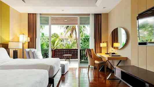 Nykyaikainen hotellihuone, jossa kaksi yhden hengen vuodetta, työpöytä, peili ja parveke vihreällä näkymällä. (Tekoälyn luoma teksti)