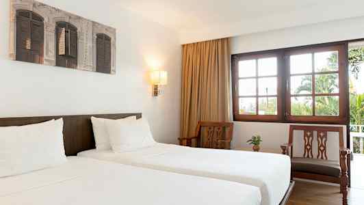 Hotellihuone kahdella erillisvuoteella ja vaaleista puusta valmistetuilla kalusteilla. (Tekoälyn luoma teksti)