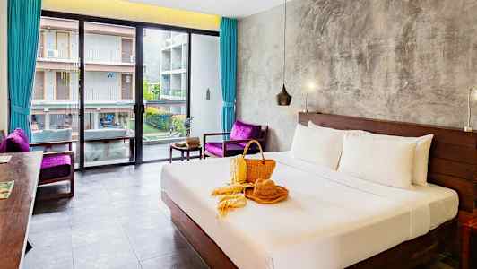 Hotellihuone, jossa pedattu parivuode, ikkuna rakennukseen päin ja koristelu sängyllä. (Tekoälyn luoma teksti)