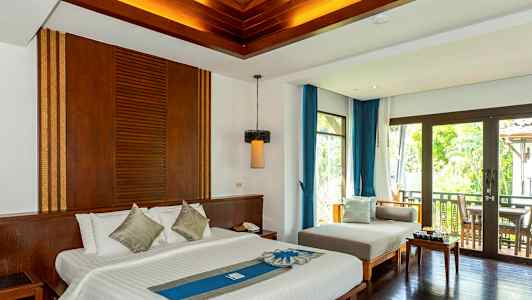 Hotellihuone, jossa on parivuode, oleskelualue ja parveke näkymällä. (Tekoälyn luoma teksti)