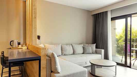 Nykyaikainen olohuone, harmaa sohva, puupöytä ja suuret ikkunat. (Tekoälyn luoma teksti)