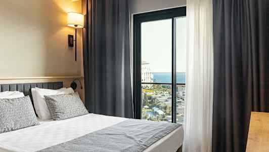 Hotellihuone, jossa on parivuode ja parveke merinäköalalla. (Tekoälyn luoma teksti)