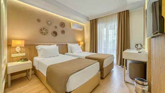 Hotellihuone, jossa on kaksi erillistä sänkyä, työpiste ja neutraalit värisävyt. (Tekoälyn luoma teksti)