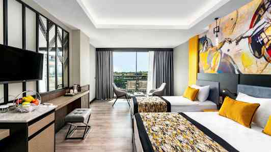 Huone, jossa on kaksi yhden hengen vuodetta ja nykyaikainen sisustus. (Tekoälyn luoma teksti)