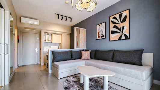 Modernisti sisustettu huone, jossa keittiö, sohva ja seinäkoristeita. (Tekoälyn luoma teksti)