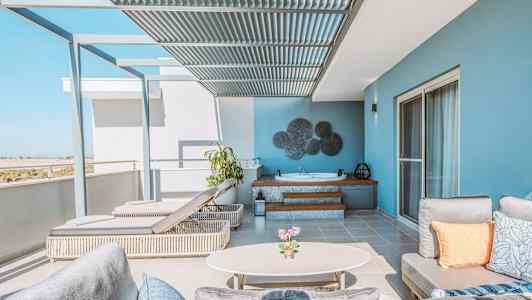 Terassi, jossa moderneja huonekaluja, poreallas ja näkymä. (Tekoälyn luoma teksti)