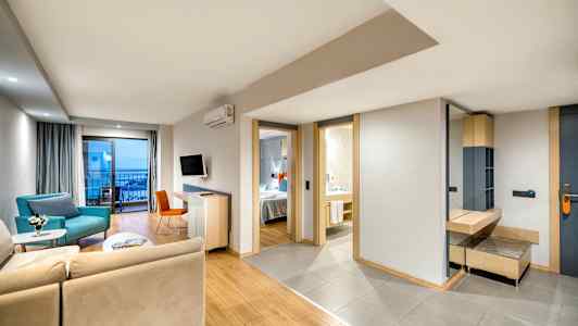 Kuva modernista hotellisviitistä, jossa on oleskelualue, makuuhuone ja kylpyhuone. (Tekoälyn luoma teksti)